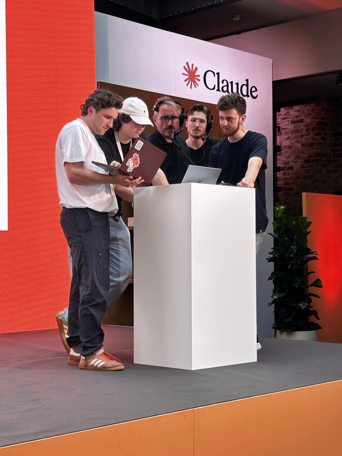 Builder am Demo-Podium unter dem Claude-Logo